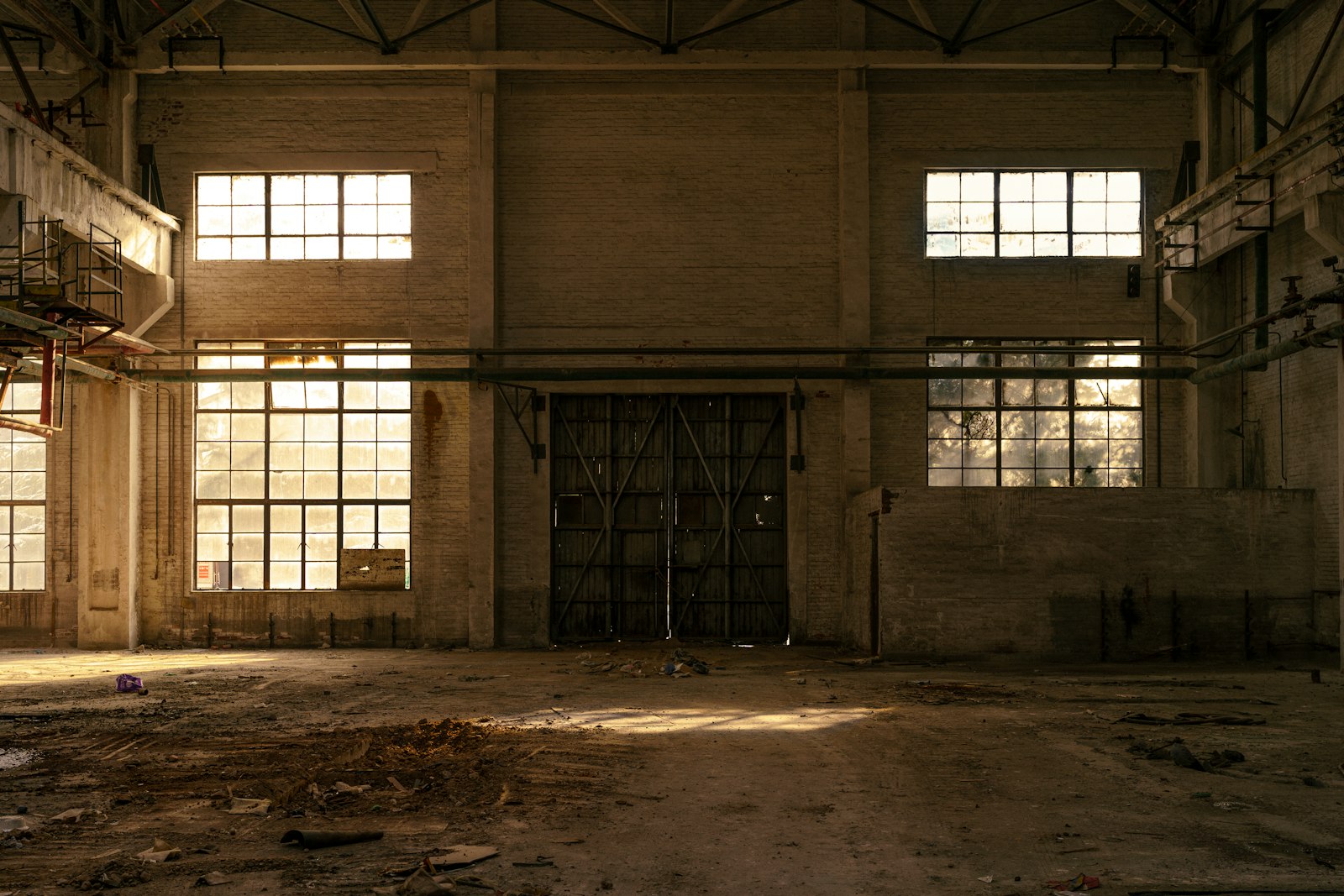Evening light through the tall windows of an empty industrial building